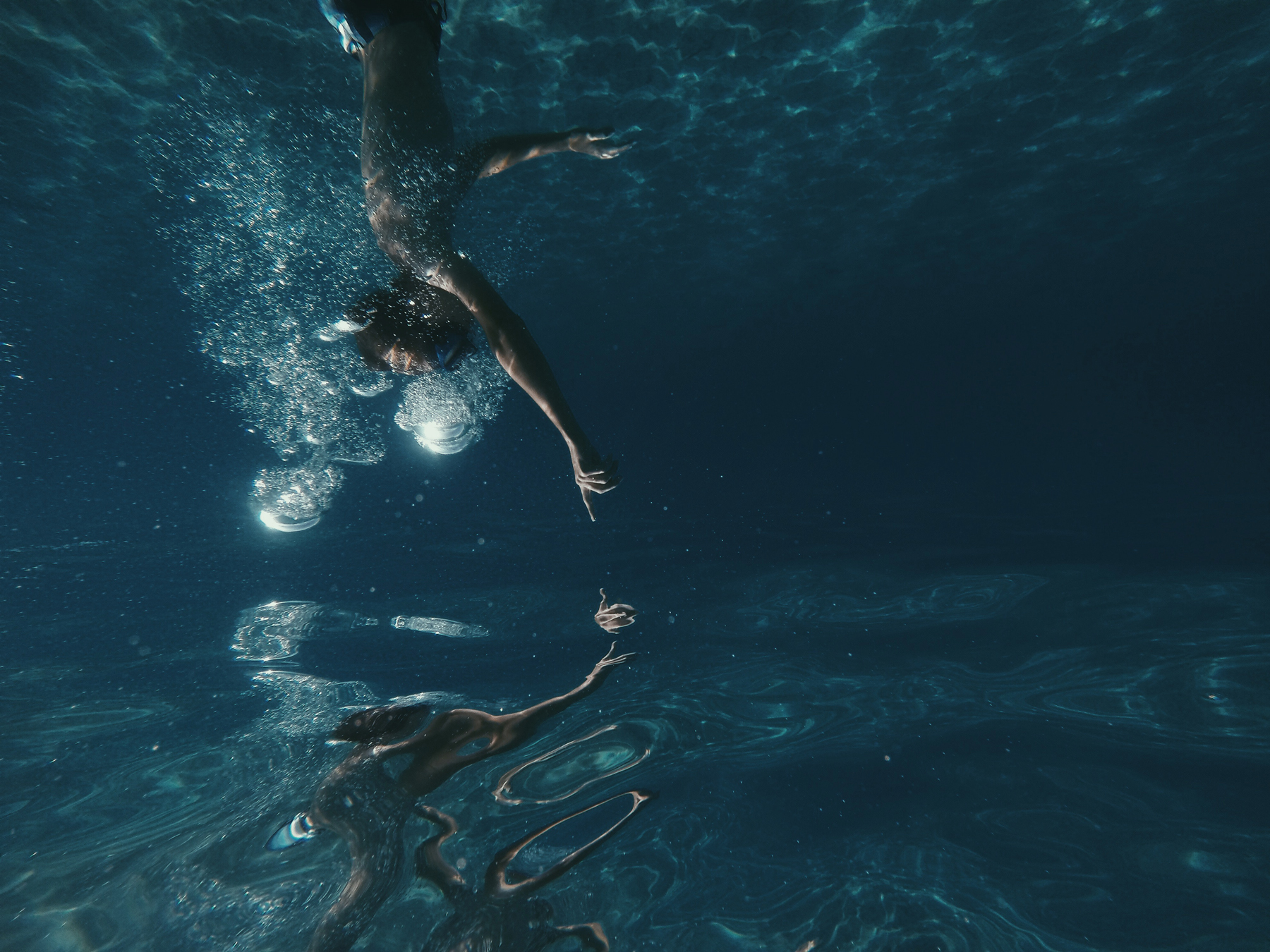 Réflexion de l'image d'un plongeur à la surface de l'eau