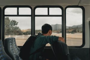 jeune homme regardant par la fenêtre d'un bus