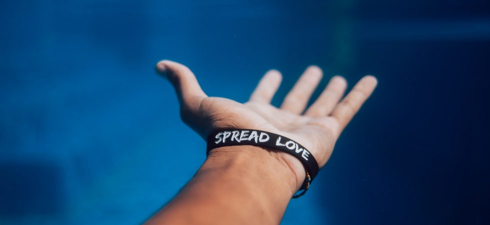 Main tendue avec un bracelet "spread love"