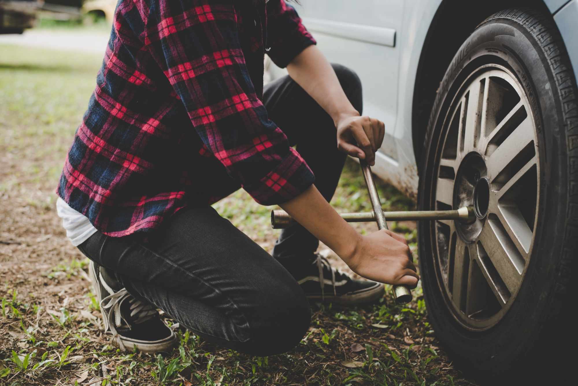 Personne en train de démonter une roue de voiture pour la changer